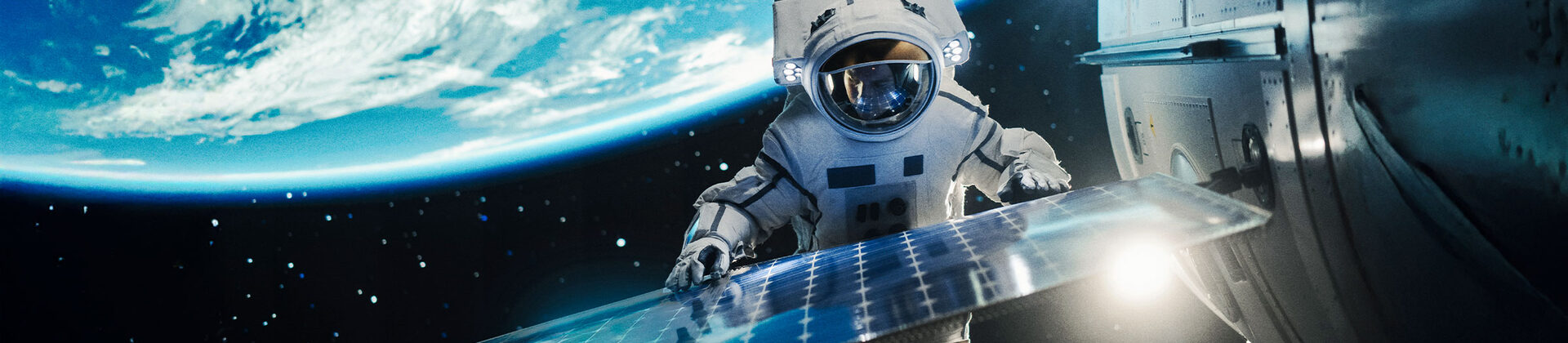 Eine Person in einem Raumanzug schwebt im Weltall, im Hintergrund ist die Erde zu sehen,