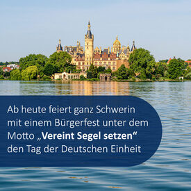 Ein Foto des Schweriner Schlosses, im Vordergrund das Wasser des Sees. Darauf steht in weißer Schrift auf blauem Grund "Ab heute feiert ganz Schwerin mit einem Bürgerfest unter dem Motto „Vereint Segel setzen“ den Tag der Deutschen Einheit"