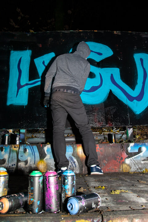 Die Teilnehmer probieren sich beim Sprayen an der Graffiti-Wand aus.
