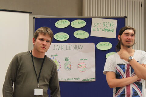 Zwei junge Männer präsentieren die Ergebnisse einer Gruppenarbeit.