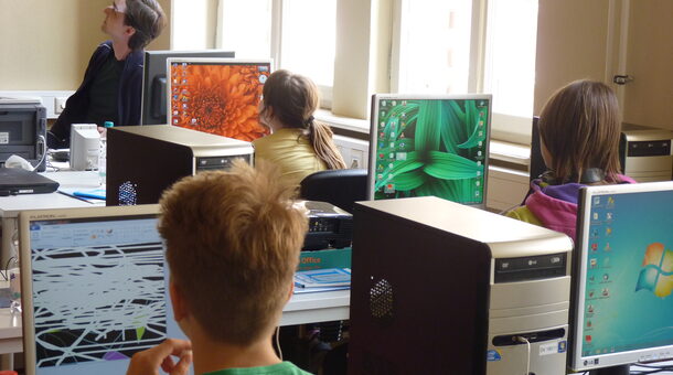 Kinder an PC Arbeitsplätzen schauen zur Kursleiterin