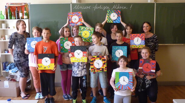 Gruppenbild: Die Kinder zeigen selbstgestaltete Wanduhren