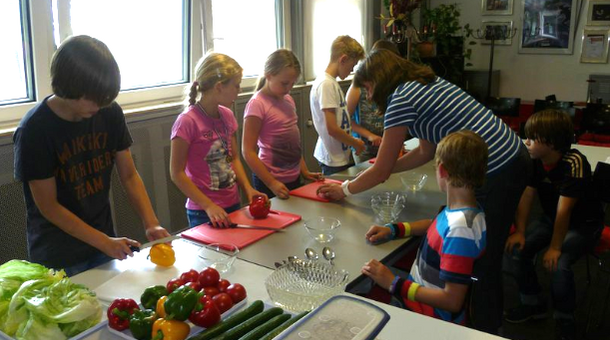 Kinder bereiten Essen zu.