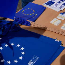 EU-Fähnchen und Taschen im europäischen blau liegen auf einem Tisch