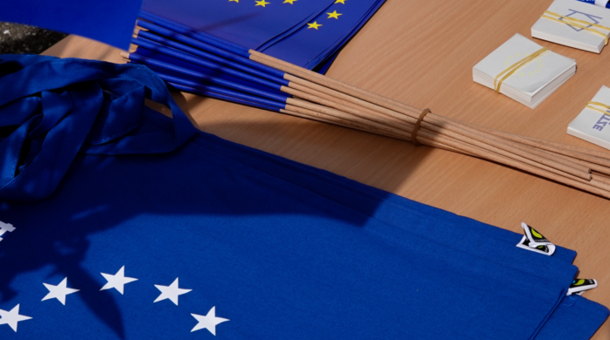 EU-Fähnchen und Taschen im europäischen blau liegen auf einem Tisch