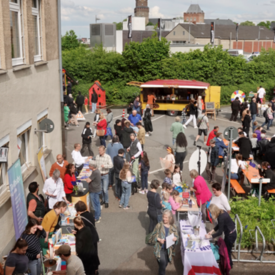 Blick auf Teilnehmer*innen beim Europafest der vhs Kleve. Im Hintergrund ist das Stadtpanorama von Kleve zu sehen.