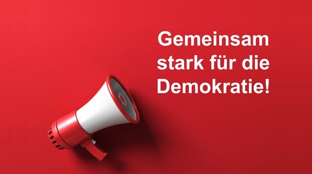 Ein Megafon auf rotem Untergrund. Daneben steht in weiß geschrieben Gemeinsam stark für die Demokratie