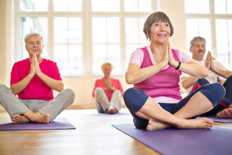 Group of happy seniors practising yoga
